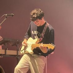 a man playing an electric guitar on stage