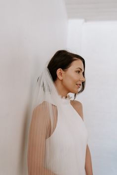 a woman in a white dress is wearing a veil