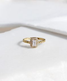 a diamond ring sitting on top of a white cloth