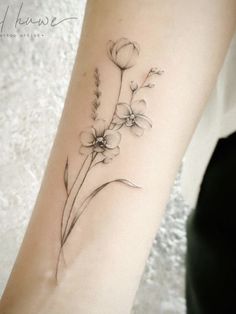 a woman's arm with flowers on it and the word flower written in cursive writing