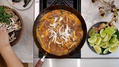 a person cooking food in a skillet on the stove top next to other dishes