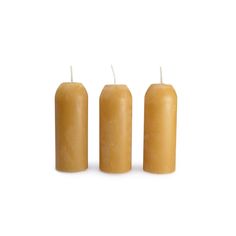 three candles are lined up on a white surface