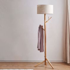 a wooden coat stand with a lamp next to it