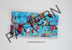 two pieces of blue fabric with colorful designs on them, one has a red bow