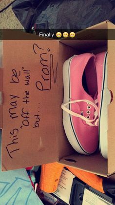 a pink tennis shoe in a cardboard box with writing on the side and other items around it