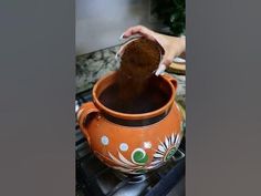 a person is pouring something into a pot