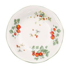 a white plate with red berries and green leaves on the rim, against a white background