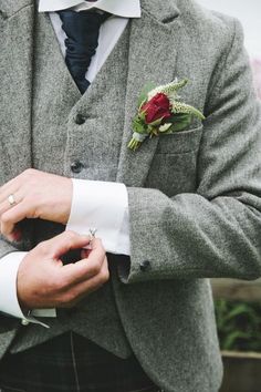 a man wearing a suit and tie with a boutonniere on his lapel