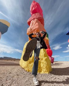 a man standing in front of a giant rock formation with his feet on the ground