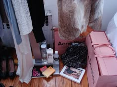 the closet is packed with clothes and other personal care items, including an open pink box