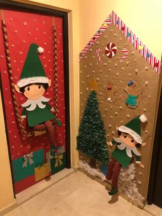 two elfs standing next to each other in front of a door decorated with christmas decorations