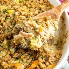 a casserole dish with meat and vegetables being scooped from the casserole