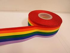 a roll of rainbow colored tape sitting on top of a white table next to a pair of scissors