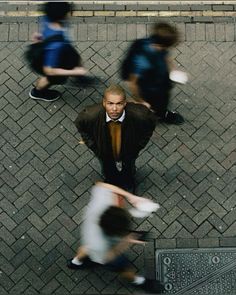 an overhead view of people walking down the street, with one man wearing a suit and tie