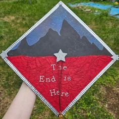 a hand holding a graduation cap with the words, the end is here