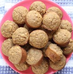 a pink plate filled with muffins on top of a blue and white table cloth