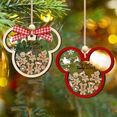 two mickey mouse ornament hanging from a christmas tree