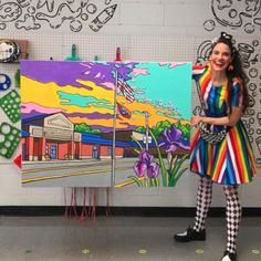 a woman standing in front of a colorful painting