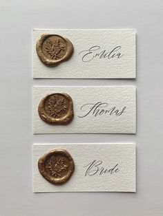 three different types of wax seals on white cards with gold foil stamping and writing