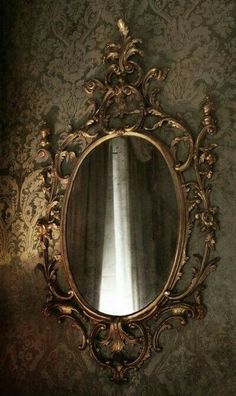 an ornate gold mirror hanging on the wall