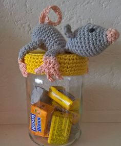 a crocheted toy mouse in a jar filled with school supplies