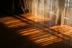 sunlight shining through sheer curtains onto the floor