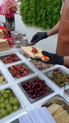 a table topped with trays of grapes and crackers