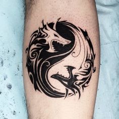 a black and white tattoo on the leg of a man with a dragon in it