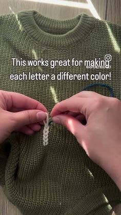 two hands are tying a string to a sweater that says, this works great for making each letter a different color