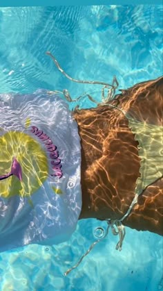 a person in a swimming suit with an umbrella floating on the water's surface