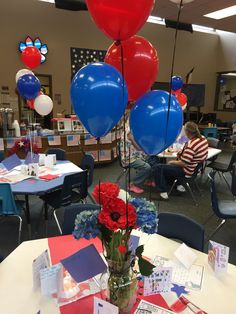 red, white and blue balloons are on display in a classroom