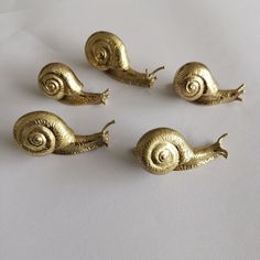 four brass snails sitting on top of each other