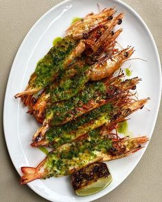 grilled shrimp with pesto sauce on a white plate