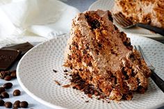 a piece of cake sitting on top of a white plate with chocolate chips around it