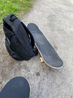 a backpack and skateboard laying on the ground