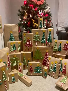 many presents are wrapped in brown paper and decorated with christmas trees on them, sitting next to a christmas tree