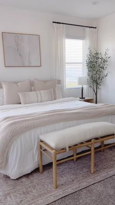 a white bed sitting in a bedroom next to a window