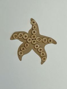 a starfish made out of wooden beads on a white surface