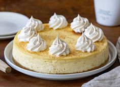 a cake with whipped cream on top sitting on a plate next to a cup and saucer