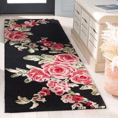 a black rug with pink roses on it