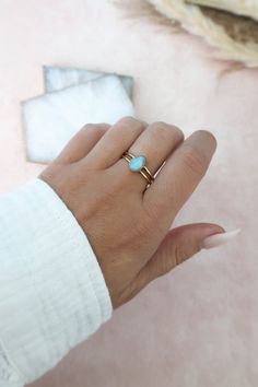 Dainty genuine Larimar ring with a double band set in 14k gold vermeil over 925 sterling silver. Love it for its minimalistic design but with a pop of color! 14k gold vermeil over 925 sterling silver Natural, Genuine Larimar Stone Size 9mm x 7mm‍ Nickel Free Hypoallergenic Please Note Larimar is a natural stone and the shade of blue will vary as well as the stone pattern and markings. Although it will look similar to the photos listed, no two stones are the same. They can range from a light milk Larimar Ring, White Spirit, Larimar Rings, Larimar Jewelry, Gold Vermeil Jewelry, Larimar Stone, Rare Stone, Vermeil Jewelry, Stone Pattern