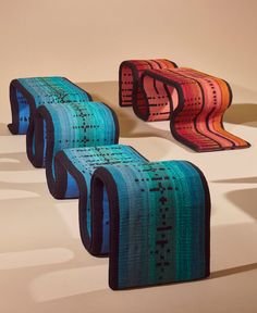 three colorful benches sitting next to each other on a white surface with shadows coming from them