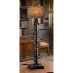 a lamp that is sitting on top of a wooden table in front of a book shelf