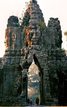 two people are walking through an ancient gate