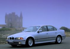 a silver car parked in front of a castle