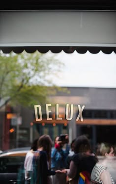 people are standing in front of a store window with the word delux on it