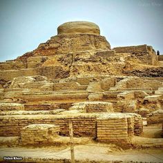 an old stone structure in the middle of a desert area with no people around it