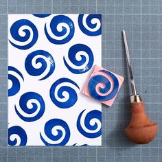 a piece of paper with blue swirls on it next to a pair of scissors