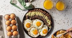 an assortment of eggs and toast on a plate with utensils next to them