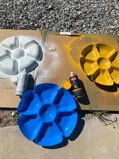 two bowls and one bowl are sitting on the ground next to some construction materials,